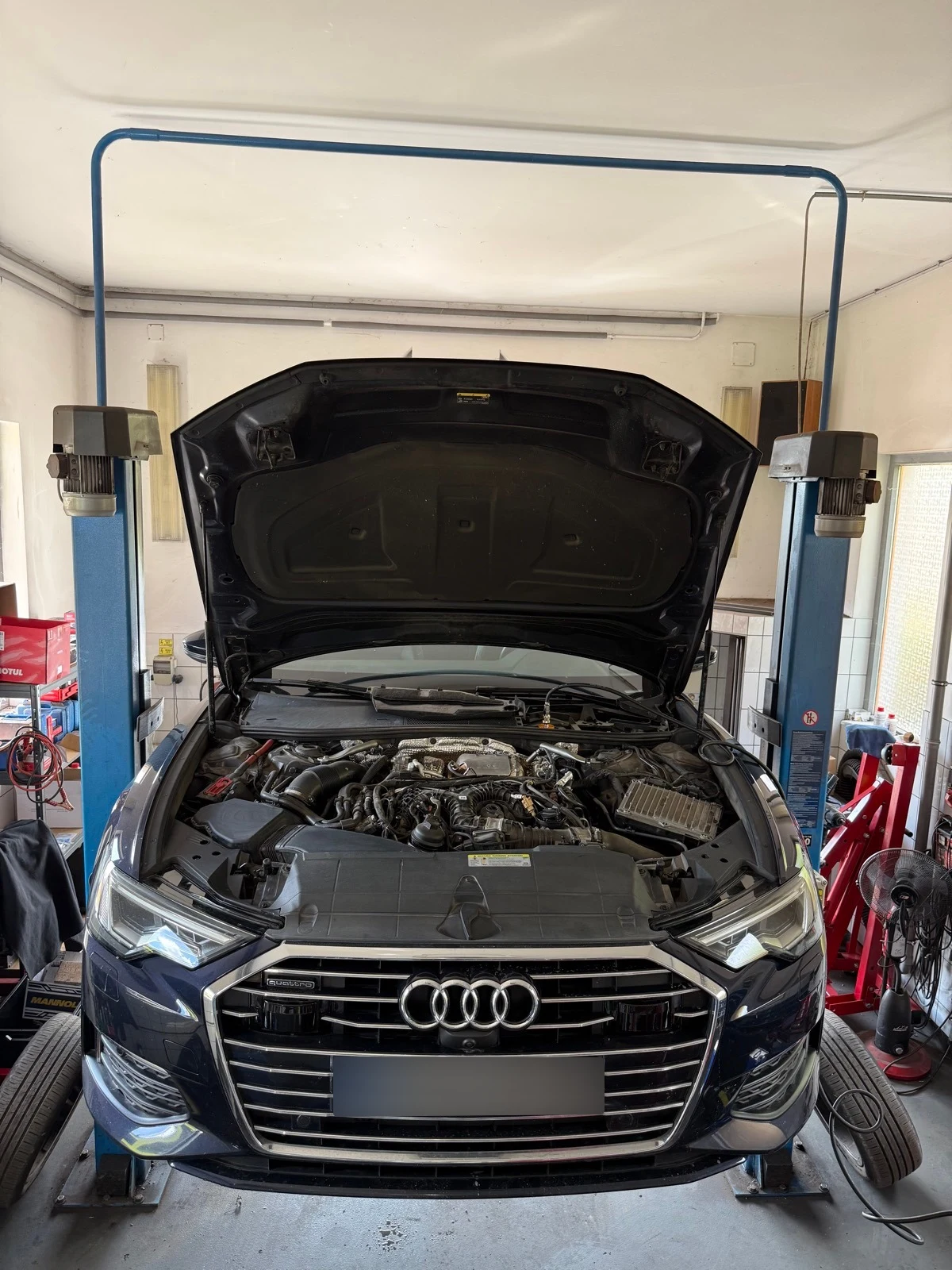 Audi nyitott motorháztetővel a Kohán Service műhelyében, szemből