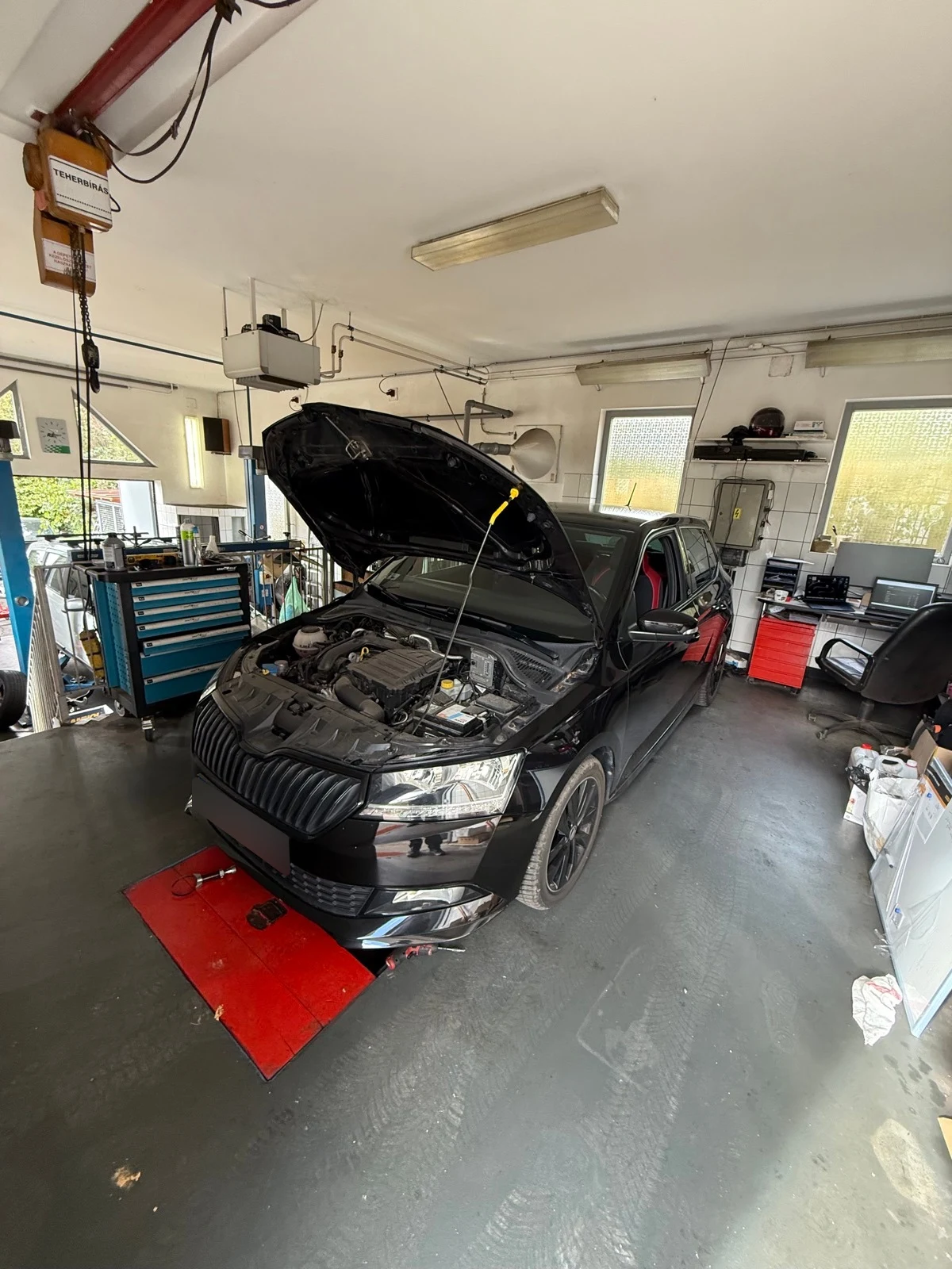 Škoda nyitott motorháztetővel a műhelyben.