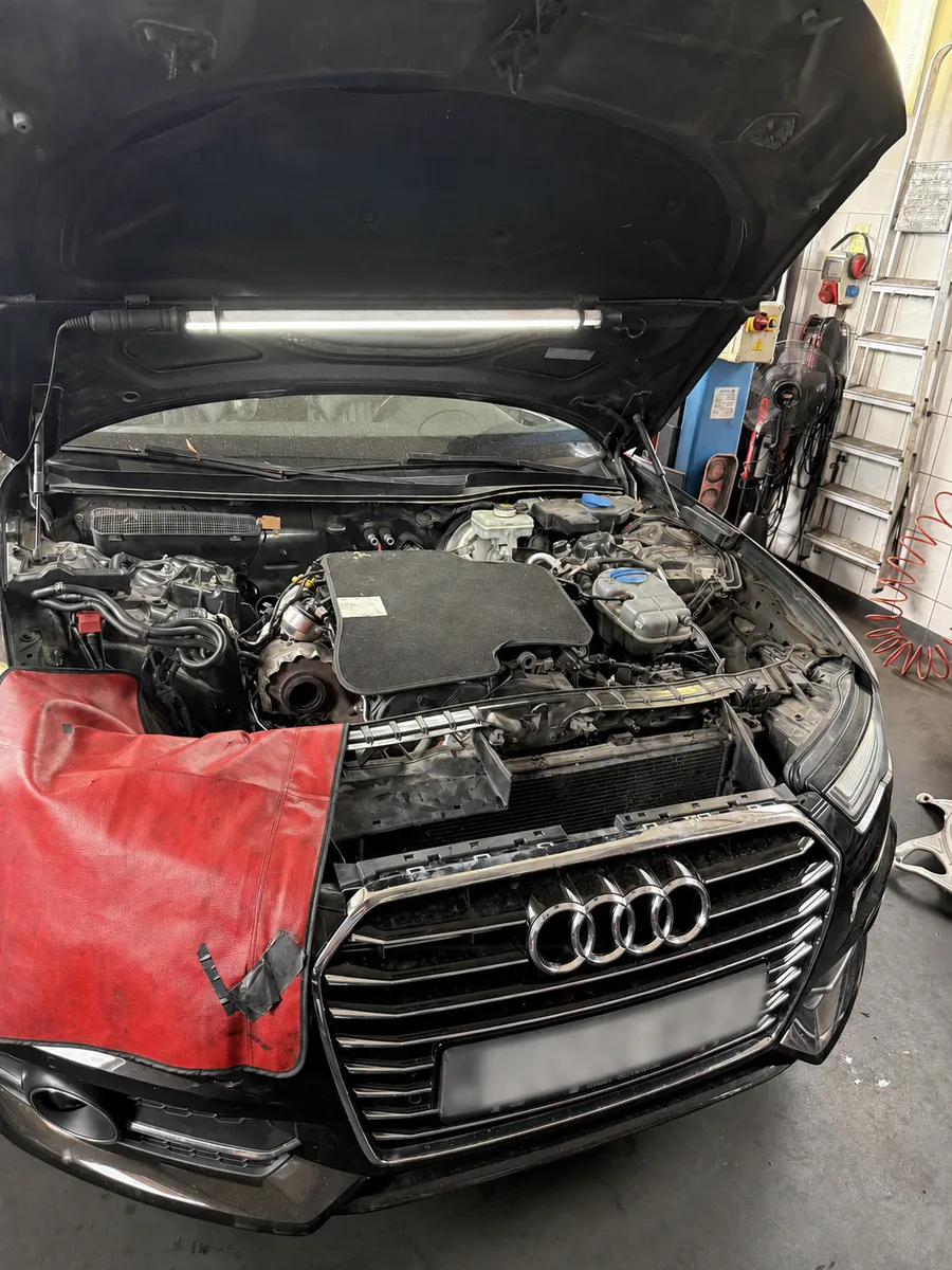 Audi nyitott motorháztetővel, kitakart rendszámmal